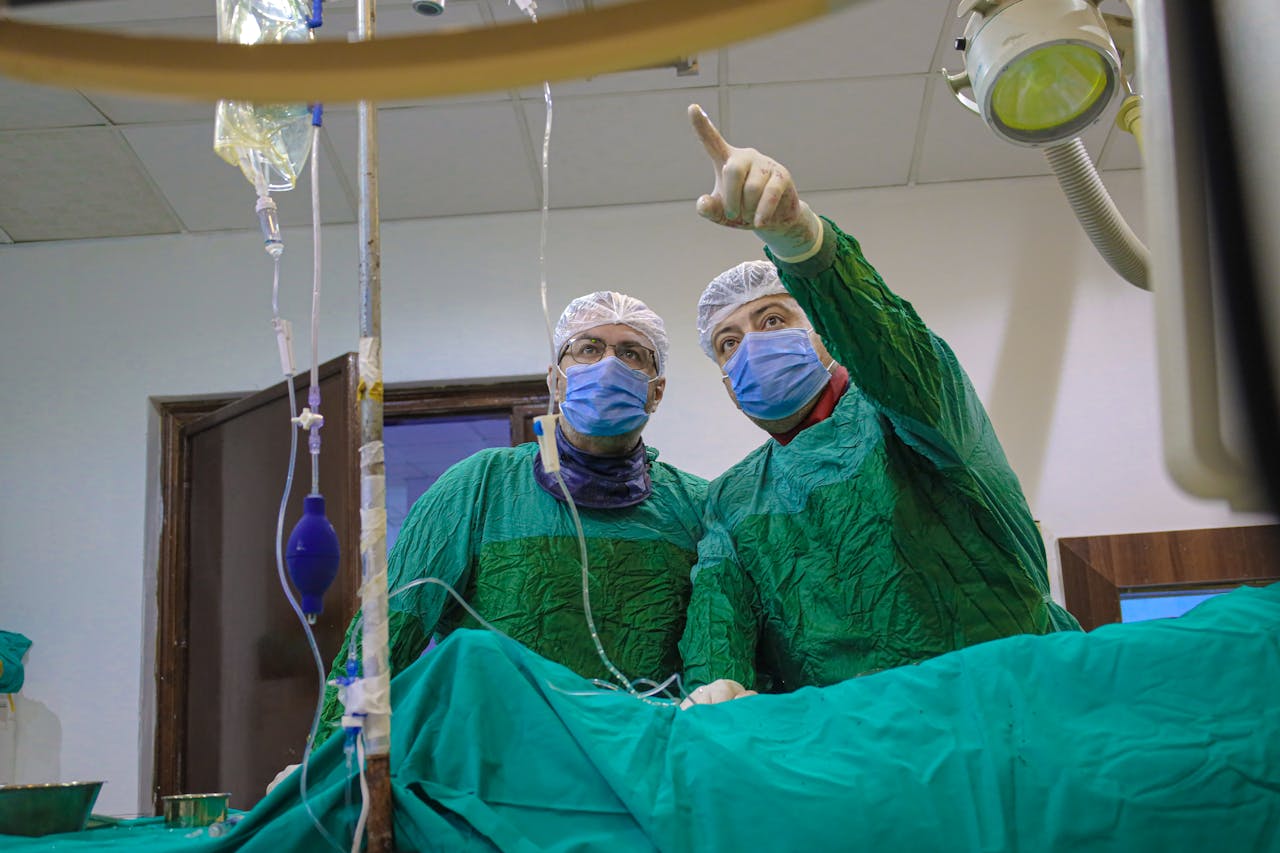 Two medical professionals operate in a Syrian hospital room, focused and equipped.
